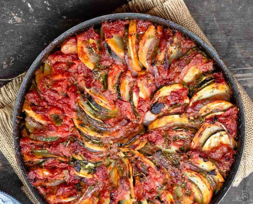 Ένα ταψί με ζεστό, λαχταριστό ρατατούι, με ομοιόμορφα κομμένα λαχανικά και χυμούς