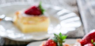 Κομματια κέικ που δείχνει τρεις διακριτές στρώσεις: μια πιο σκούρα βάση, μια κρεμώδης μεσαία στρώση και μια πιο ανοιχτή, πορώδης ανώτερη στρώση, πασπαλισμένο με άχνη ζάχαρη.