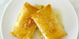 Χρυσαφένια Φέτα Τυλιχτή με Μέλι, πασπαλισμένη με σουσάμι, σε ένα πιάτο σερβιρίσματος