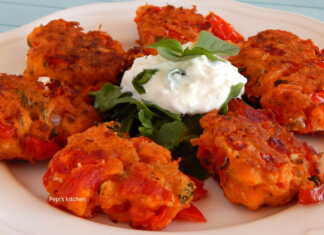 Πιατέλα με χρυσαφένιους ντοματοκέφτεδες Σαντορίνης, γαρνιρισμένους με φύλλα φρέσκιας μέντας και δίπλα ένα μπολάκι γιαούρτι