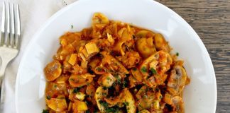 Μανιτάρια με πράσο γιαχνί σε πιάτο, γαρνιρισμένο με ψιλοκομμένο μαϊντανό και φέτα.