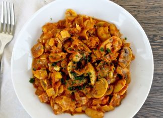 Μανιτάρια με πράσο γιαχνί σε πιάτο, γαρνιρισμένο με ψιλοκομμένο μαϊντανό και φέτα.