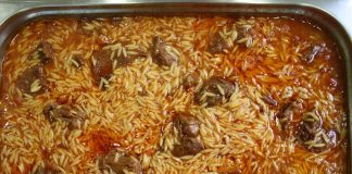 Ένα πήλινο σκεύος με ζουμερό γιουβέτσι μοσχάρι, μελωμένο κριθαράκι και κόκκινη σάλτσα, πασπαλισμένο με κεφαλοτύρι