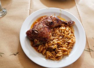 Γιουβέτσι με Κοτόπουλο Ένα πιάτο γιουβέτσι με κοτόπουλο και κριθαράκι σε κόκκινη σάλτσα, πασπαλισμένο με τριμμένη φέτα.