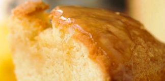 Αφράτο κέικ βουτύρου σε πιατέλα, περιχυμένο με λαμπερή σάλτσα λεμονιού