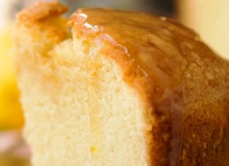 Αφράτο κέικ βουτύρου σε πιατέλα, περιχυμένο με λαμπερή σάλτσα λεμονιού