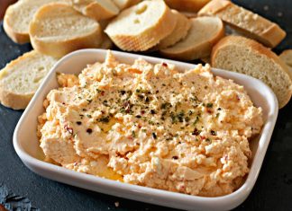 Κρεμώδης τυροκαυτερή σε μπολ με κομματάκια πιπεριάς Φλωρίνης και πασπαλισμένη με μπούκοβο και ελαιόλαδο