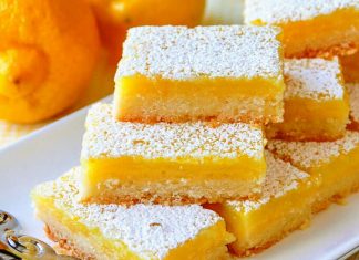 Μια φέτα από το δροσερό γλυκάκι λεμονιού πασπαλισμένο με άχνη