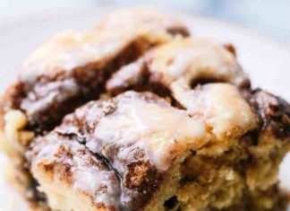 Κέικ με κανέλα, καλυμμένο με λευκό γλάσο βανίλιας και ορατούς στροβιλισμούς κανέλας.