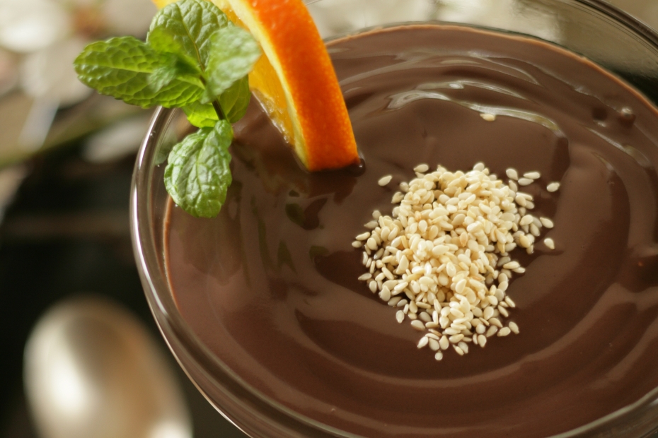 dairy-free-chocolate-mousse-w-tahini-almond-milk 1 μπολ γεμάτο με σκούρα καφέ μους σοκολάτας, πασπαλισμένη με λευκό σουσάμι.