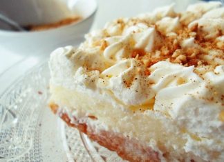 Κοντινό πλάνο σε ένα κομμάτι από Γλυκό με Φρυγανιά από Ζάκυνθο, που αναδεικνύει τις στρώσεις φρυγανιάς, κρέμας και σαντιγί.