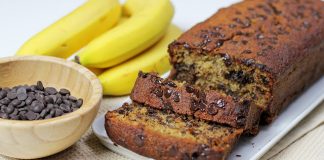 Κέικ Μπανάνας: Πεντανόστιμο και πανεύκολο! Μια φέτα από υγρό κέικ μπανάνας με λιωμένα κομμάτια σοκολάτας και θρυμματισμένα καρύδια, πασπαλισμένη με άχνη ζάχαρη