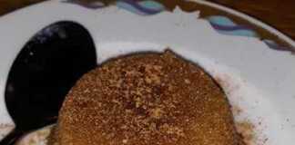 Παραδοσιακός σιμιγδαλένιος χαλβάς, σερβιρισμένος σε φόρμα, με ραβδώσεις από το σχήμα της φόρμας, πασπαλισμένος με κανέλα.