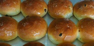 Ένα ταψί με χρυσαφένια, στρογγυλά σταφιδόψωμα.