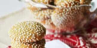 Στρογγυλά, επίπεδα μπισκότα καλυμμένα με σουσάμι, ψημένα μέχρι να πάρουν χρυσαφένιο χρώμα, τοποθετημένα σε ταψί με λαδόκολλα.