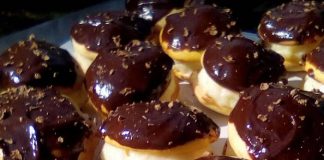 Μια σειρά από μικρά, στρογγυλά κοκάκια, σαντουιτσάκια από μπισκότο γεμιστά με λευκή κρέμα και καλυμμένα με σκούρο γλάσο σοκολάτας.