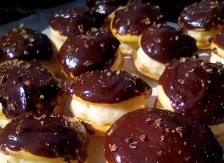 Μια σειρά από μικρά, στρογγυλά κοκάκια, σαντουιτσάκια από μπισκότο γεμιστά με λευκή κρέμα και καλυμμένα με σκούρο γλάσο σοκολάτας.