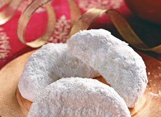 Πιατέλα με παραδοσιακούς κουραμπιέδες σε σχήμα ημισελήνου, πασπαλισμένους με άχνη ζάχαρη