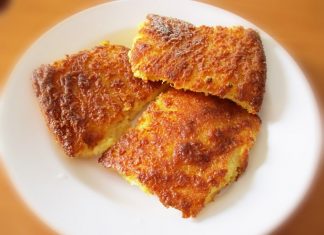 Χρυσαφένια κολοκυθόπιτα χωρίς φύλλο, κομμένη σε τετράγωνα κομμάτια, σερβιρισμένη.