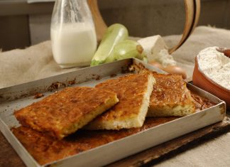 Χρυσαφένια ψημένη πίτα Κουρκουτό σε ταψί, με ρουστίκ όψη, κομμένη σε τετράγωνα κομμάτια, που αναδεικνύει το κολοκύθι και τα τυριά.