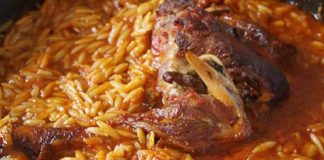 Ένα πιάτο με ζουμερό αρνάκι κοκκινιστό γιουβέτσι, με τρυφερό κρέας και κριθαράκι σε πλούσια κόκκινη σάλτσα, πασπαλισμένο με φρέσκο μαϊντανό και φέτα.