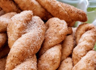 Τραγανά κουλουράκια με ζάχαρη και κανέλα, σερβιρισμένα σε πιατέλα, με χρυσό χρώμα.