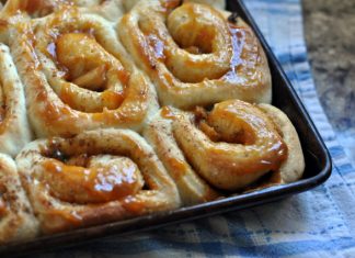 Κοντινή λήψη σε ένα ρολάκι κανέλας με γέμιση μήλου και καραμέλας