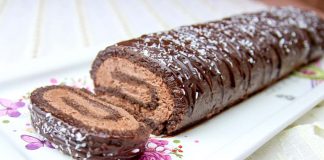 Ένα ολόκληρο κομμάτι Κορμός Σοκολάτας, περιχυμένο με γλάσο και πασπαλισμένο με καρύδα, σε ξύλινη επιφάνεια