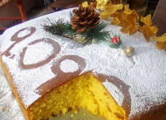 Μια ολόκληρη βασιλόπιτα πασπαλισμένη με άφθονη ζάχαρη άχνη και στολισμένη με το νούμερο του νέου έτους πάνω σε εορταστικό τραπεζομάντηλο