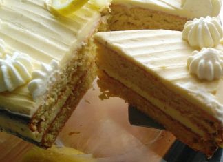 Μια εντυπωσιακή τούρτα λεμονιού με λευκή κρέμα βουτύρου και ξύσμα λεμονιού σε πιατέλα