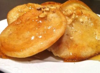 Φωτογραφία με ζεστές τηγανίτες περιχυμένες με μέλι και καρύδια.