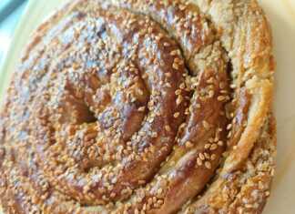 Χρυσαφένια στριφτή ταχινόπιτα σε σχήμα σαλιγκαριού πασπαλισμένη με σουσάμι και περιχυμένη με σιρόπι μελιού