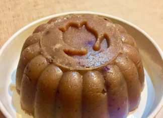 Ένας ολόκληρος Χαλβάς Σιμιγδαλένιος με Καρύδια και Σταφίδες, σερβιρισμένος σε πιατέλα, πασπαλισμένος με κανέλα