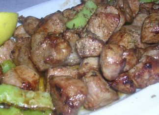 Μια λαχταριστή χοιρινή τηγανιά στο τηγάνι με μέλι και βαλσάμικο περιτριγυρισμένη από πιπεριές και πυκνή σάλτσα