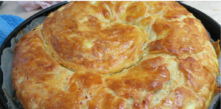 Μια χρυσαφένια, στριφτή τυρόπιτα σε ένα ταψί.