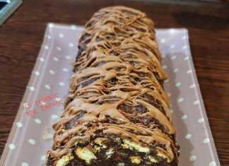 Σοκολατένιος κορμός με μπισκότα και καρύδια, παγωμένος και έτοιμος για σερβίρισμα.