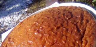 Ένα χρυσαφένιο σιροπιαστό κέικ μέσα σε ταψί, κομμένο σε ρόμβους, που αναδεικνύει την αφράτη και ζουμερή εσωτερική του δομή.