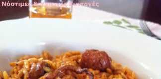 Ένα πιάτο με ζουμερό χταπόδι κοκκινιστό με κριθαράκι σε πλούσια κόκκινη σάλτσα, γαρνιρισμένο με φρέσκο πιπέρι και πάπρικα.