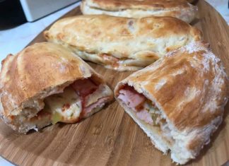 Χρυσαφένια φουσκωτά calzone μόλις βγήκαν από τον φούρνο, με λιωμένο τυρί να ξεπροβάλλει από την αφράτη ζύμη τους