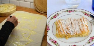 Μια χρυσαφένια, τραγανή μπουγάτσα στιγμής κομμένη σε κομμάτια, πασπαλισμένη με άχνη ζάχαρη και κανέλα, σε ένα ταψί.