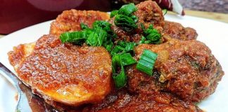 Ένα πιάτο Σουτζουκάκια με πατάτες γιαχνί, με πλούσια κόκκινη σάλτσα, γαρνιρισμένο με φρέσκο μαϊντανό