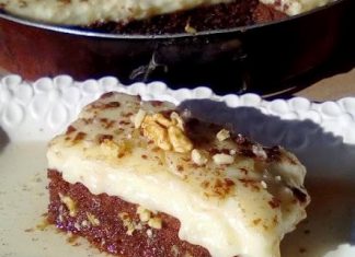 Κομμάτι καρυδόπιτας σοκολάτας με στρώση λευκής κρέμας, πασπαλισμένο με τριμμένη σοκολάτα και καρύδια