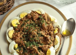 Μια πλούσια σαλάτα με μαύρα φασόλια πασπαλισμένη με μαϊντανό και γαρνιρισμένη με σφήνες βραστού αυγού σε πιατέλα