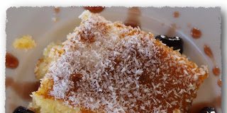 Ένα κομμάτι από σιροπιαστό ινδοκάρυδο, πασπαλισμένο με επιπλέον ινδοκάρυδο, δείχνοντας την αφράτη και ζουμερή του υφή.