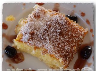 Ένα κομμάτι από σιροπιαστό ινδοκάρυδο, πασπαλισμένο με επιπλέον ινδοκάρυδο, δείχνοντας την αφράτη και ζουμερή του υφή.