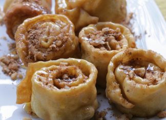 Παραδοσιακά Ικαριώτικα Ξεροτήγανα τυλιγμένα σε σχήμα τριαντάφυλλου, περιχυμένα με χρυσό μέλι και πασπαλισμένα με καρύδια και κανέλα