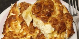 Μια χρυσαφένια, φρεσκοψημένη πατσαβουρόπιτα με εμφανή τα σουρωμένα φύλλα, κομμένη σε τετράγωνα κομμάτια μέσα σε ένα ταψί.