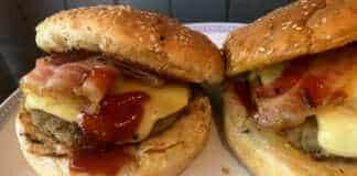 Λαχταριστό σπιτικό burger με διπλό μπιφτέκι, λιωμένο τυρί τσένταρ, καραμελωμένα κρεμμύδια και τραγανό μπέικον ανάμεσα σε αφράτα ψωμάκια.