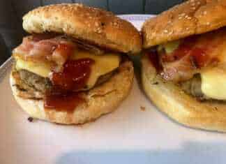 Λαχταριστό σπιτικό burger με διπλό μπιφτέκι, λιωμένο τυρί τσένταρ, καραμελωμένα κρεμμύδια και τραγανό μπέικον ανάμεσα σε αφράτα ψωμάκια.