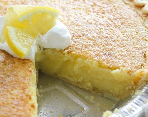 droseri lemonopita Ενα πυρεξ από κίτρινη λεμονόπιτα με μια στρώση λευκής σαντιγί στην κορυφή, τοποθετημένη σε ένα λευκό πιάτο.